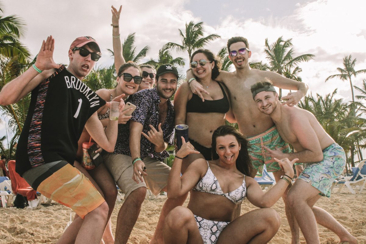 Young adults on a beach taking A group photo